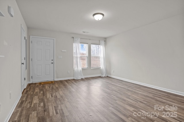 unfurnished room with dark wood-style floors and baseboards