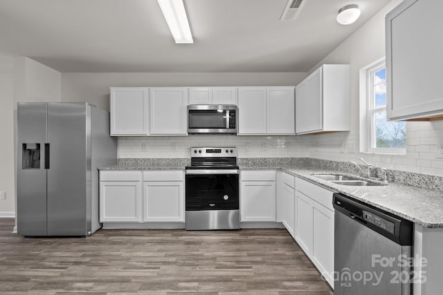 kitchen featuring appliances with stainless steel finishes, visible vents, and white cabinetry