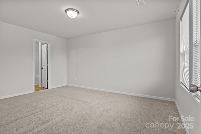 carpeted empty room with visible vents and baseboards