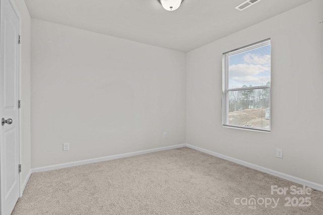 carpeted empty room with visible vents and baseboards