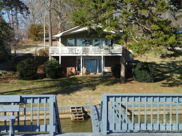 rear view of house featuring a lawn and a wooden deck