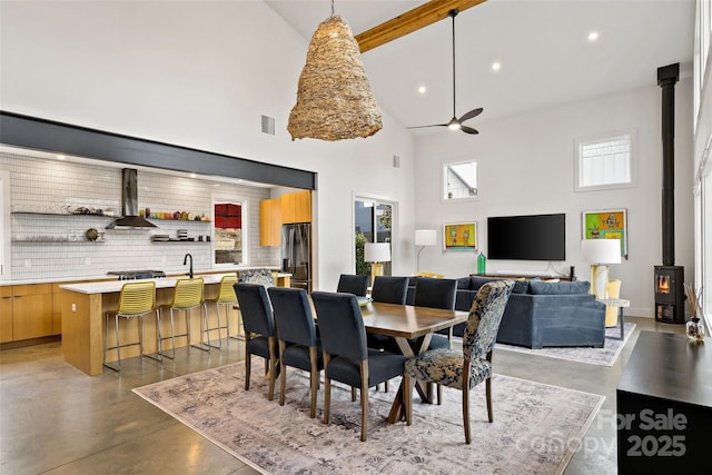 dining space with recessed lighting, visible vents, finished concrete floors, a wood stove, and ceiling fan