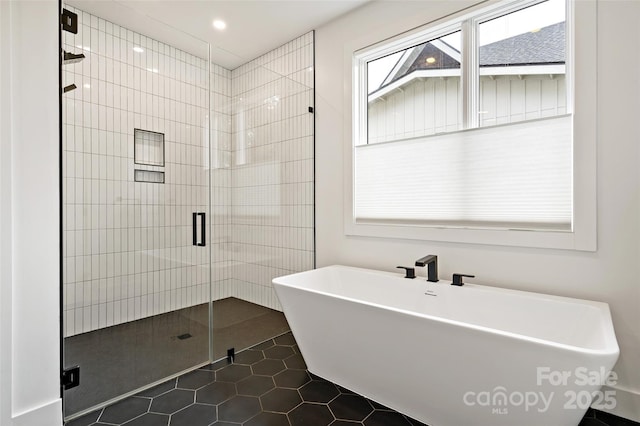 full bath featuring tile patterned flooring, a soaking tub, and a shower stall