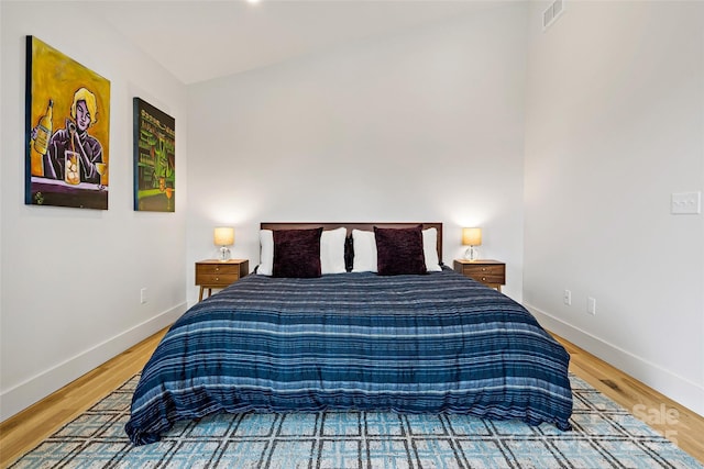 bedroom featuring wood finished floors, visible vents, and baseboards