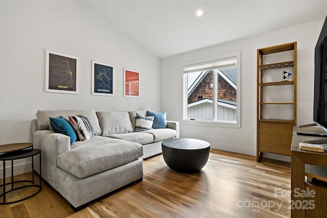 living room with light wood-style floors and vaulted ceiling