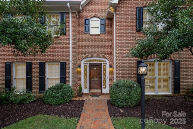 doorway to property with brick siding