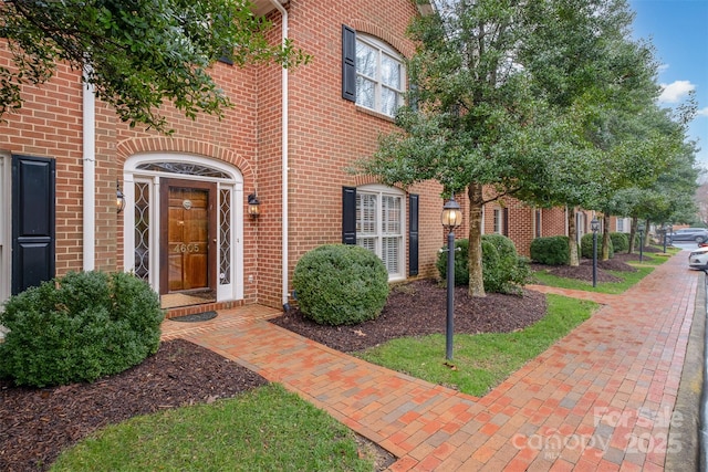 view of exterior entry with brick siding