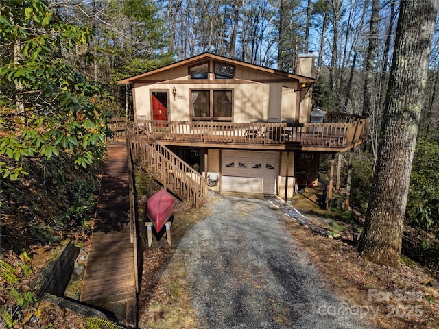 front of property featuring a garage and a wooden deck