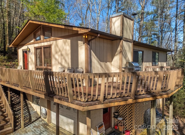 back of property with a garage and a deck