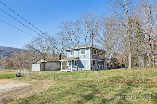 rear view of property with a porch, a yard, and fence