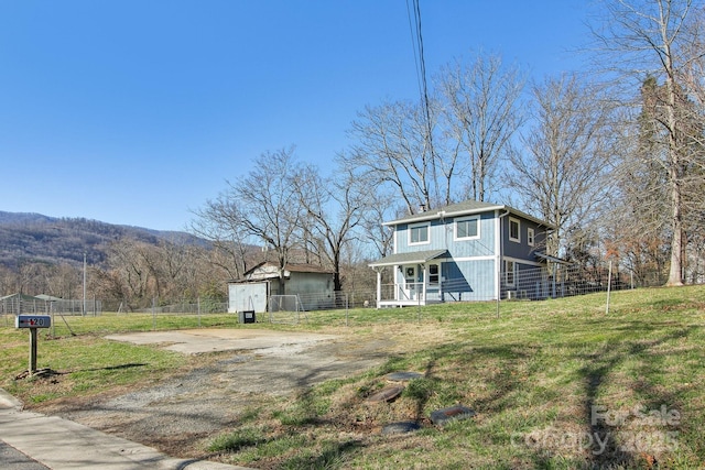 view of yard with a mountain view, driveway, and fence