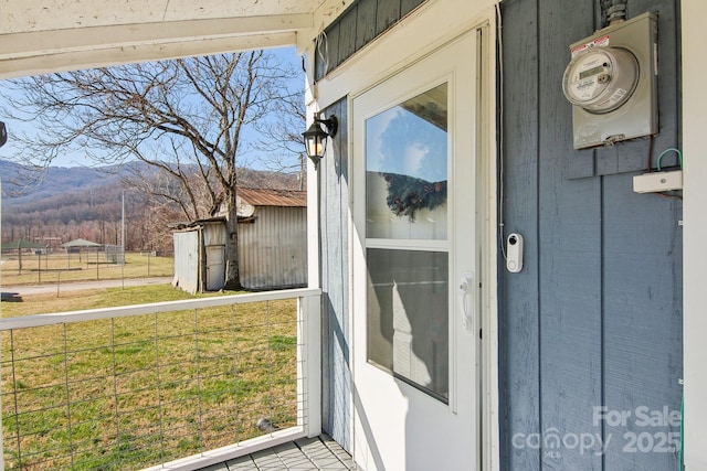 doorway to property featuring a lawn and a mountain view