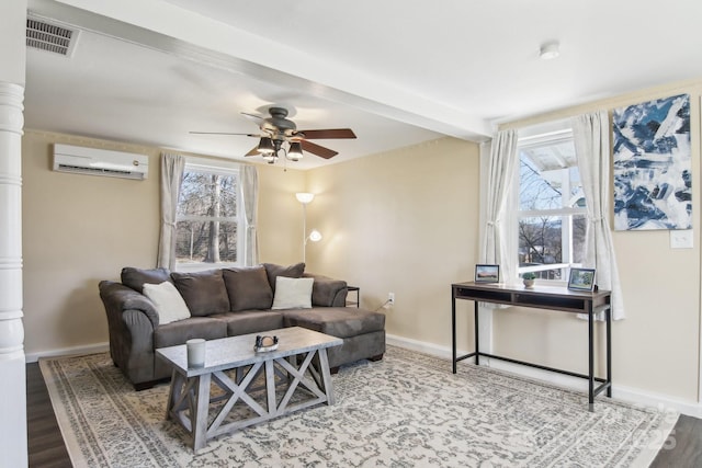 living area with visible vents, a wall mounted AC, wood finished floors, decorative columns, and baseboards