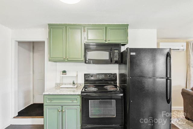 kitchen with black appliances, light stone countertops, and green cabinetry