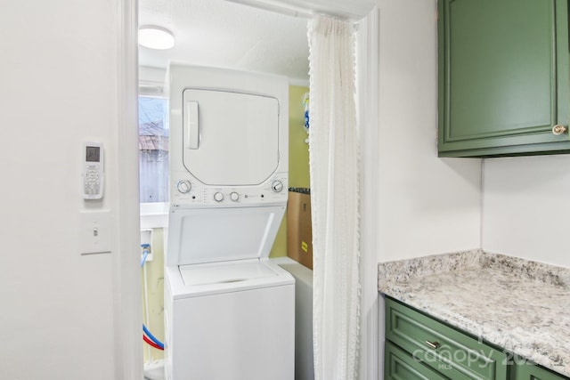 clothes washing area with stacked washer / dryer and laundry area