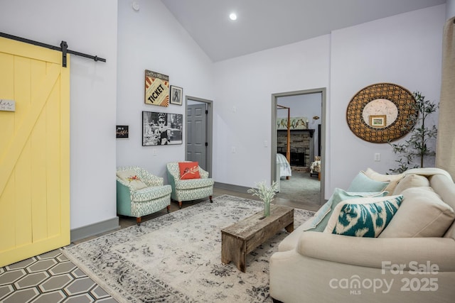 living room with a barn door and high vaulted ceiling