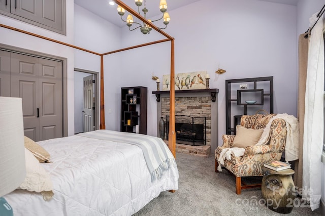 carpeted bedroom with a notable chandelier and a fireplace