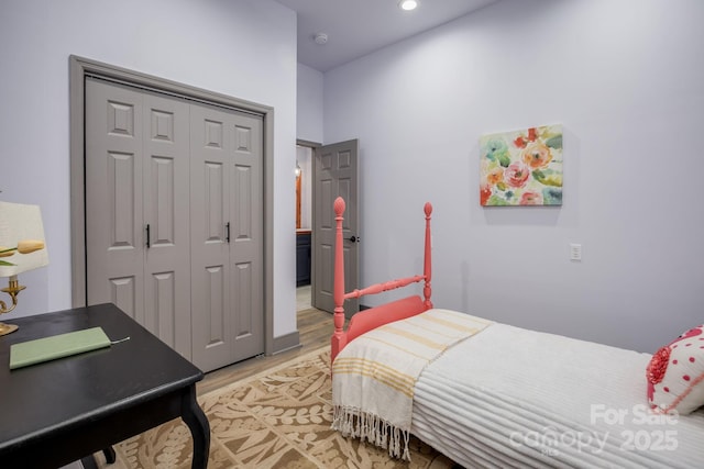 bedroom with wood-type flooring and a closet