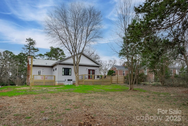 rear view of house with a yard and a deck