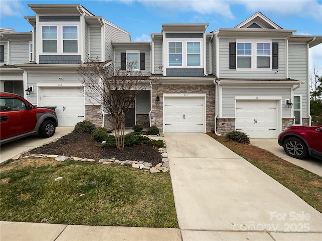 townhome / multi-family property featuring a garage, a front yard, stone siding, and concrete driveway