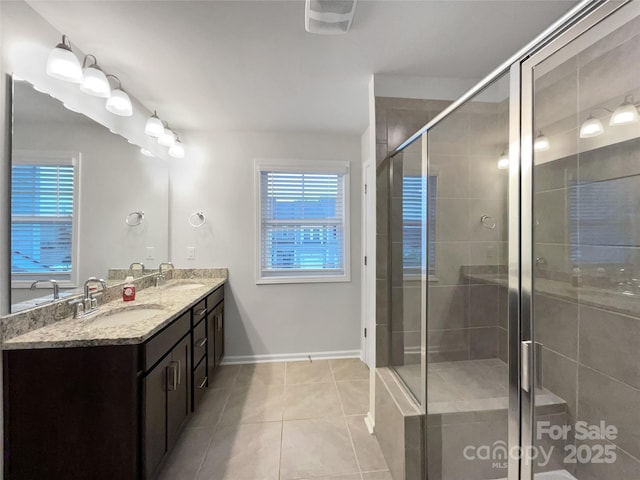 full bath with double vanity, a stall shower, plenty of natural light, and a sink