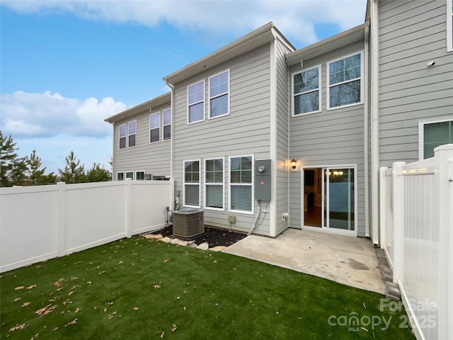 back of property with a patio area, a fenced backyard, central AC unit, and a lawn