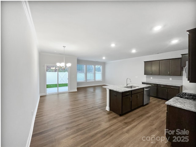 kitchen with a sink, open floor plan, dark brown cabinets, dishwasher, and an island with sink