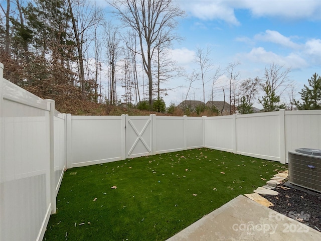 view of yard featuring central air condition unit, a fenced backyard, and a gate