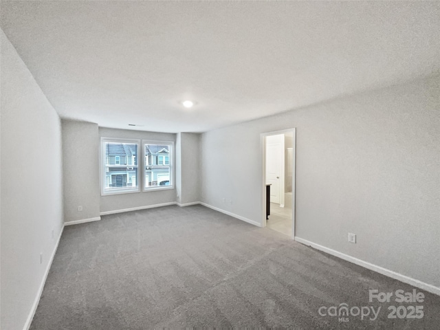 unfurnished room featuring carpet floors and baseboards