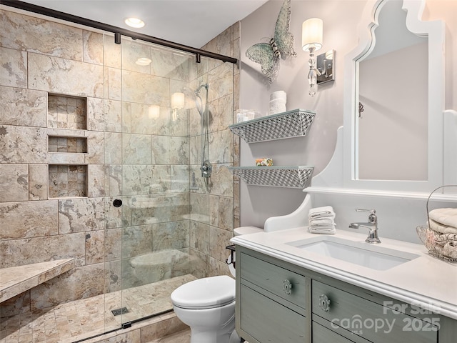 bathroom featuring a shower with door, vanity, and toilet