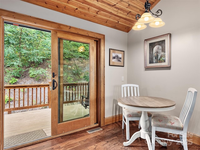 dining area with wood-type flooring, vaulted ceiling, a notable chandelier, and wood ceiling