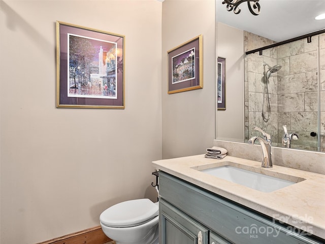 bathroom with vanity, a tile shower, and toilet