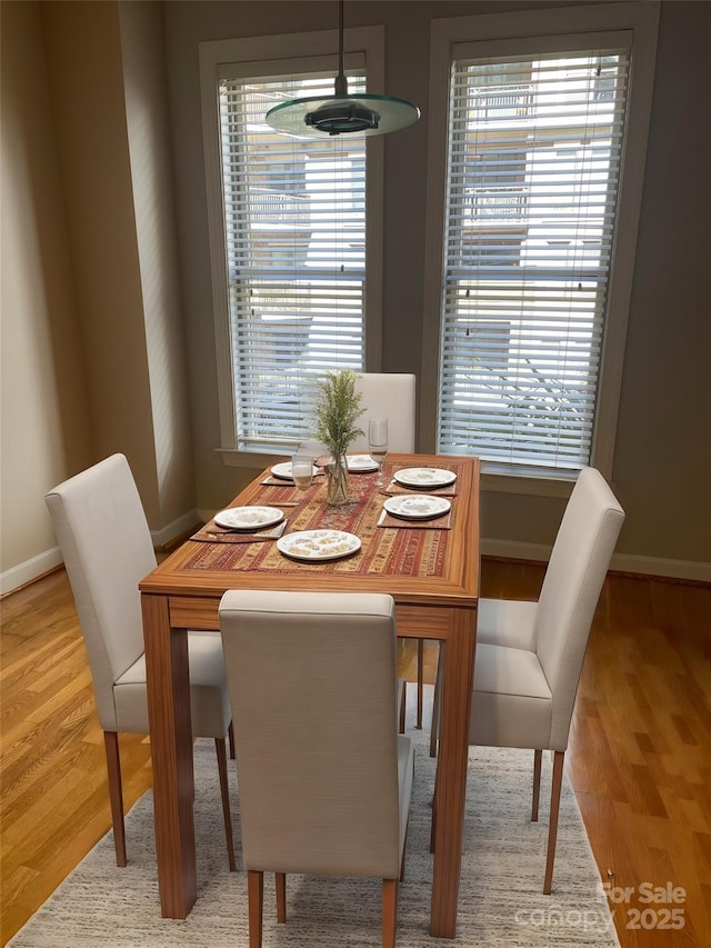 dining room featuring baseboards and light wood finished floors