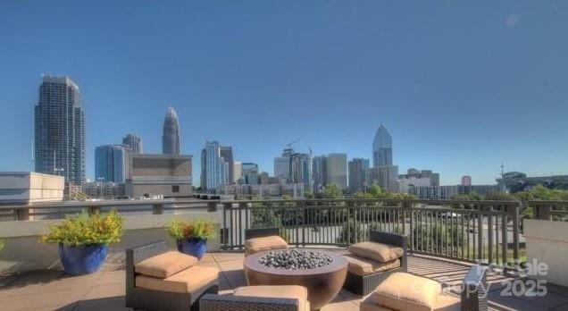 view of patio / terrace featuring a view of city and a fire pit