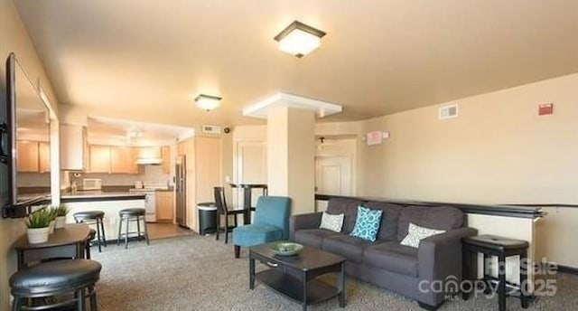 living area featuring carpet flooring and visible vents