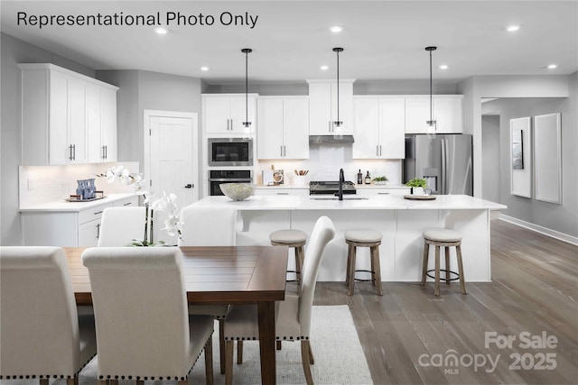 1809 Ab Moore Jr Dr Unit 3238, Indian Trail, NC 28079 - kitchen with stainless steel appliances, a sink, decorative backsplash, wood finished floors, and recessed lighting