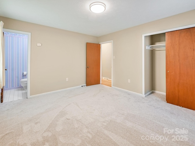 unfurnished bedroom with visible vents, carpet floors, baseboards, a closet, and connected bathroom