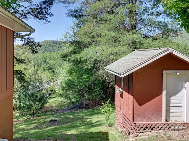 view of shed with a wooded view