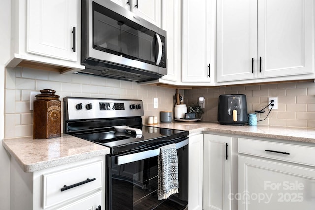 kitchen with white cabinetry, appliances with stainless steel finishes, and decorative backsplash