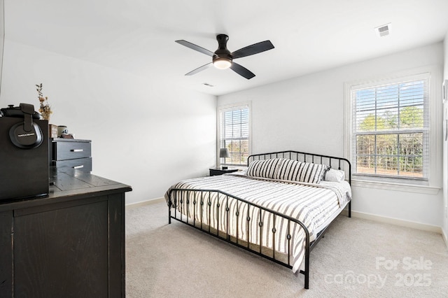 bedroom featuring a ceiling fan, light carpet, visible vents, and baseboards