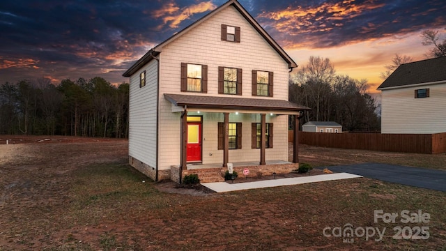 view of front of home with covered porch and fence