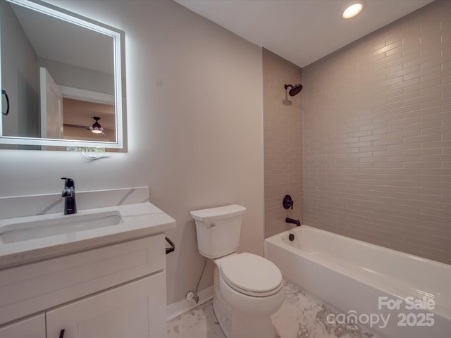 full bathroom featuring tiled shower / bath combo, vanity, and toilet