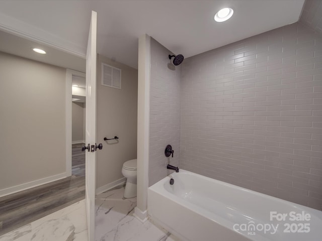 bathroom with toilet and tiled shower / bath combo