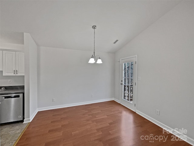 unfurnished dining area featuring hardwood / wood-style flooring, lofted ceiling, and a chandelier