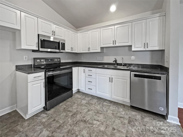 kitchen with stainless steel appliances, white cabinetry, vaulted ceiling, and sink