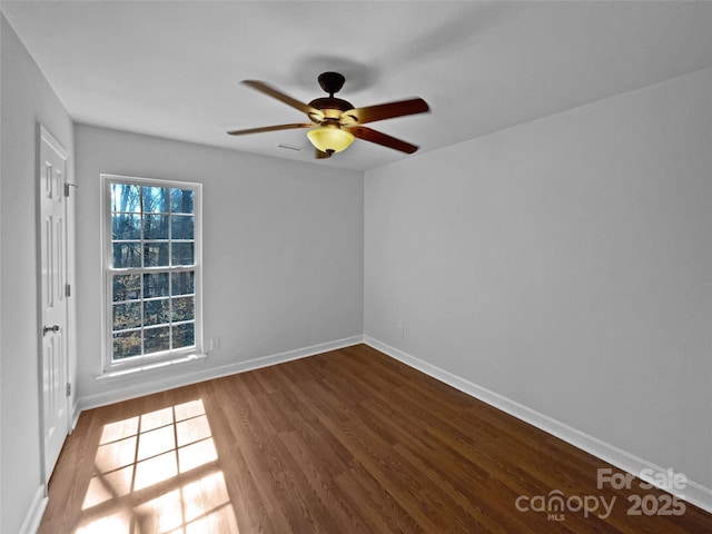 empty room featuring ceiling fan, wood-type flooring, and a wealth of natural light