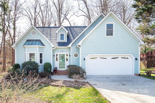 view of front of property with a garage, driveway, roof with shingles, and fence