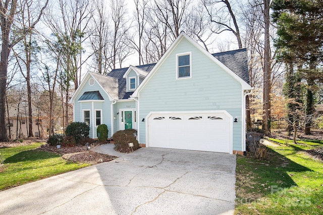 view of front of home with concrete driveway, roof with shingles, and a front lawn