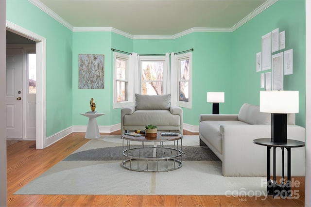 sitting room featuring ornamental molding, baseboards, and wood finished floors