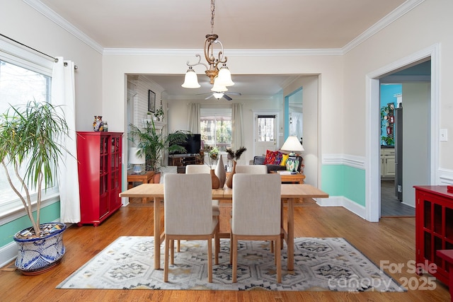 dining room featuring a notable chandelier, crown molding, and wood finished floors